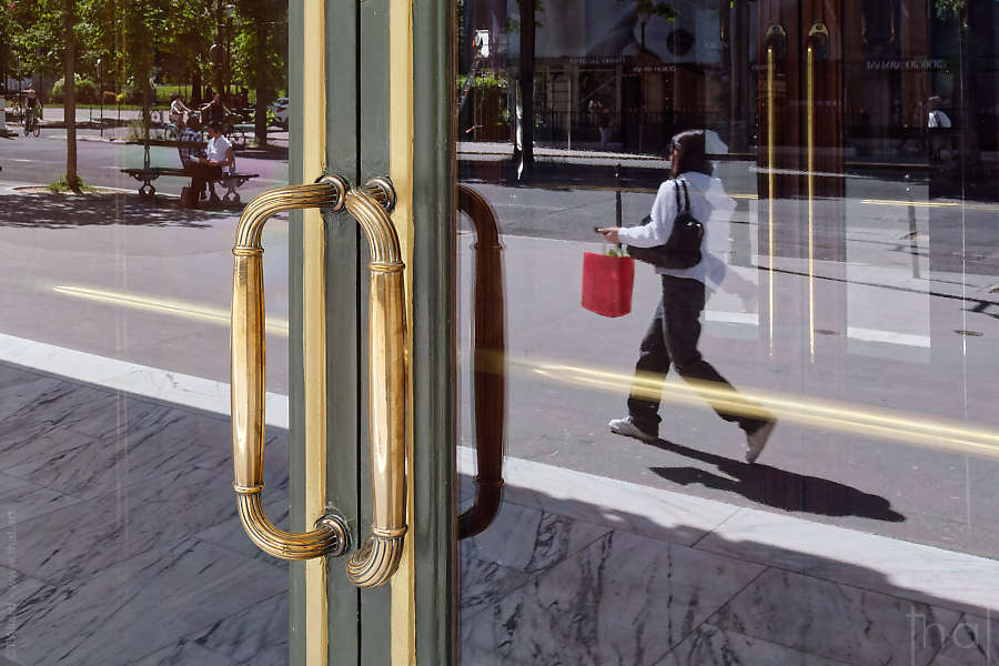 The reflection of a passer-by in the glass door of the façade of the Théâtre des Champs-Elysées